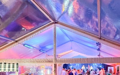 Ein Festzelt mit transparentem Vordach ist innen beleuchtet
