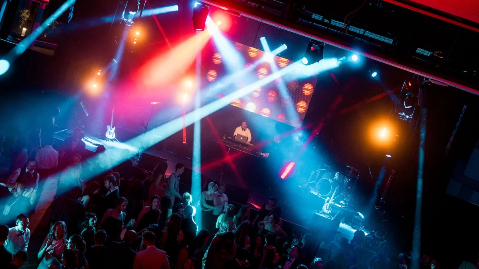 DJ im Einsatz mit Lichtshow und Partygäste