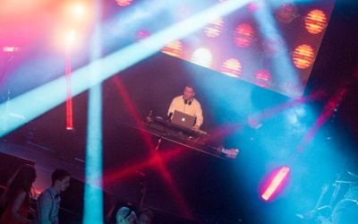 DJ im Einsatz mit Lichtshow und Partygäste