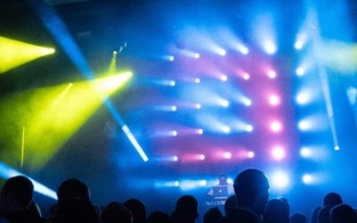 DJ im Einsatz mit Lichtshow in blau, gelb, magenta