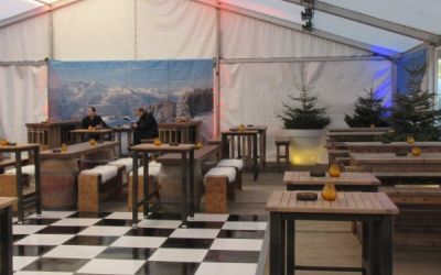 Eventzelt mit rustikaler Einrichtung und Schachbrettmuster auf dem Boden.