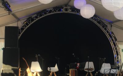 Blick zur Bühne in einem Eventzelt mit rustikaler Einrichtung und Schachbrettmuster auf dem Boden.