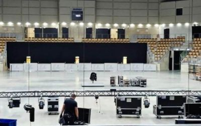 Bühnenaufbau durch Mitarbeiter von Starlight in einer Sporthalle.