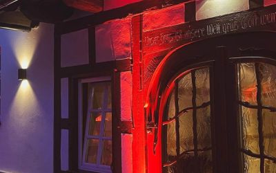 Eingangstor eines Fachwerkhaus rot angeleuchtet.
