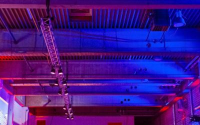 Event von MBN in einer bunt beleuchteten Lagerhalle mit Tischen aus EURO-Paletten.